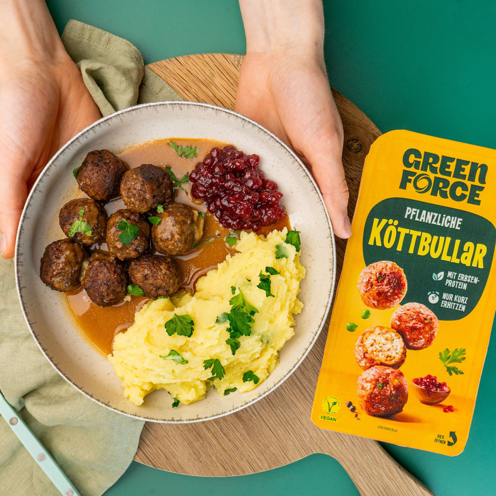 Vegane Köttbullar mit Rahmsoße, Kartoffelpüree und Preiselbeeren mit einer Packung Greenforce Köttbullar neben dem Teller