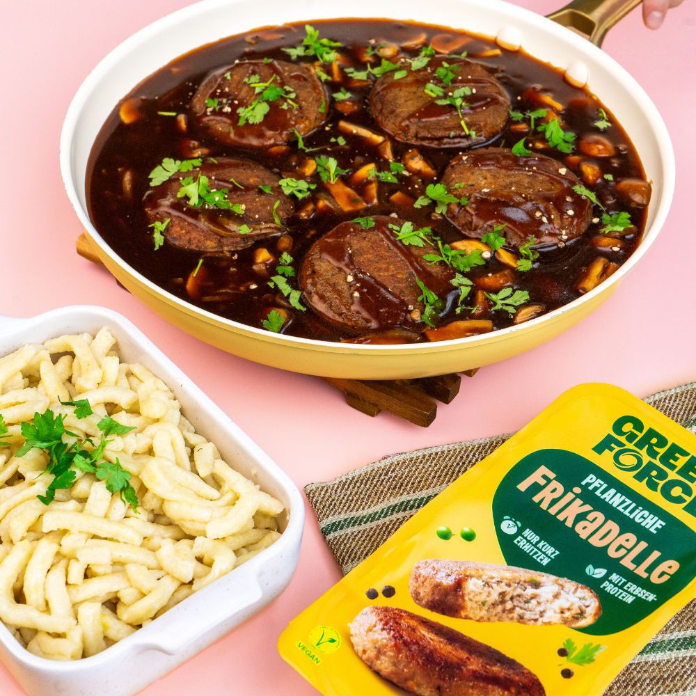 Vegane Frikadellen in veganer Pilzbratensauce in einer Pfanne mit einem Schälchen Spätzle und Greenforce Frikadellen Packung