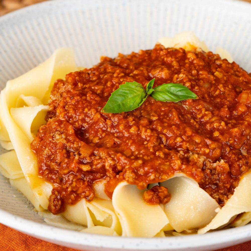 Close Up vegane Bolognese auf Bandnudeln getoppt mit Basilikum